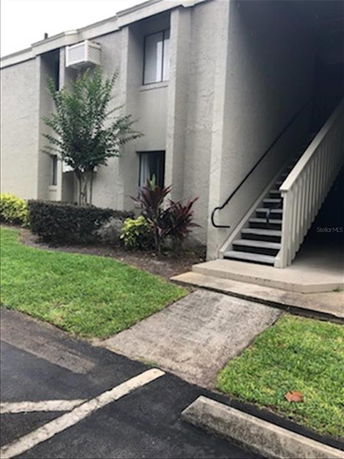 Front view of a two-story apartment building with an exterior staircase.