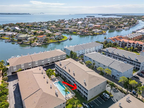 Panoramic view of residential buildings with waterway and distant landscape.