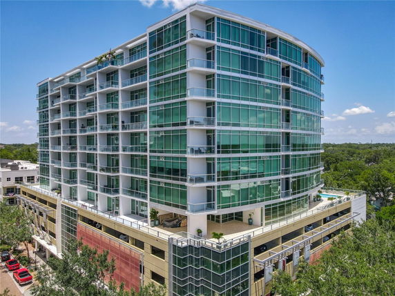 Front view of a multi-story building with large glass windows and balconies.