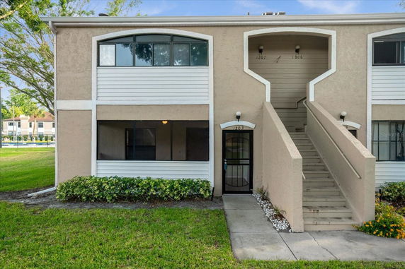 Front view of a two-story residential building with exterior staircase.