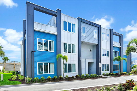 Front view of a modern multi-story building with blue and white paneling.