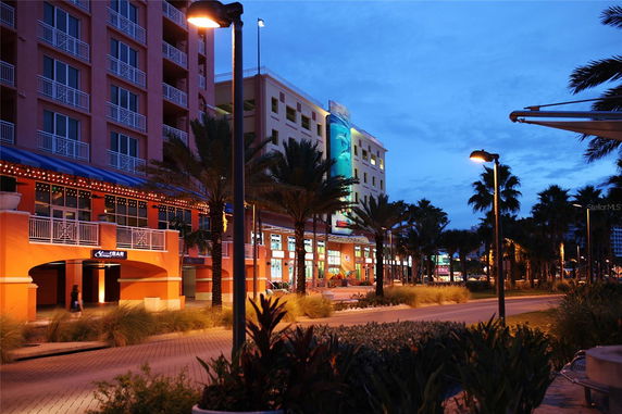 Front view of a multi-story building with balconies and ground-level shops.