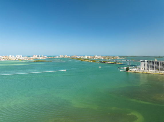 Wide-angle view of a coastal area with buildings and bridges.