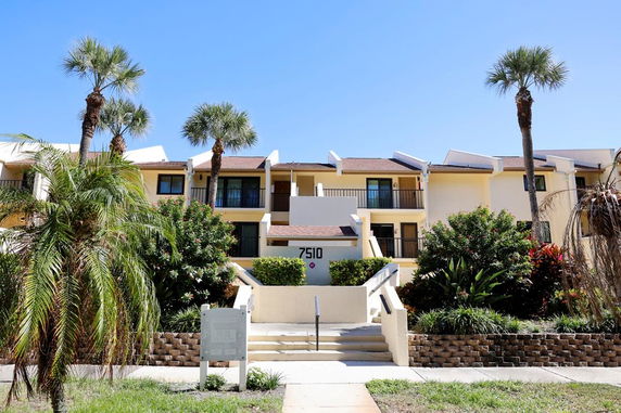 Front view of a multi-story apartment building with balconies.