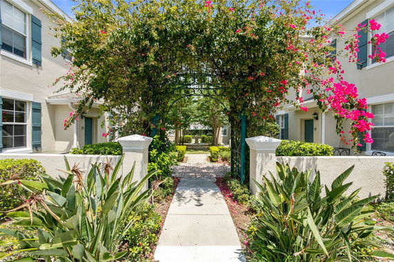 Front view of two-story residential buildings with arched greenery.