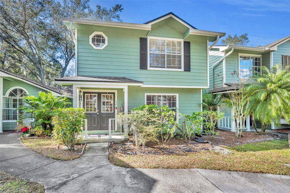 Front view of a two-story house with green siding and black shutters.