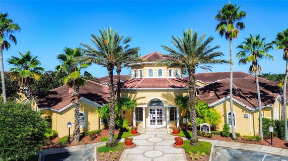 Front view of a building with a circular entrance and palm trees.