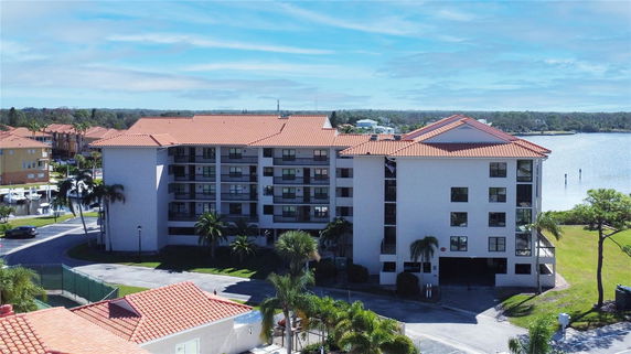 Front view of a multi-story apartment building with a red-tiled roof.