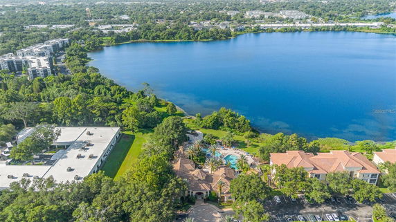 Aerial view showing buildings and a large lake surrounded by trees.