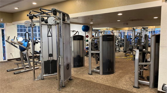 Indoor gym area with various exercise machines and equipment.
