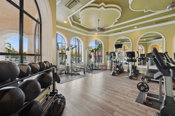 Interior view of a modern gym with exercise equipment and large windows.