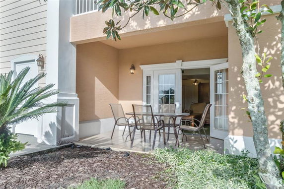Front view of a house with a patio and glass doors leading inside.