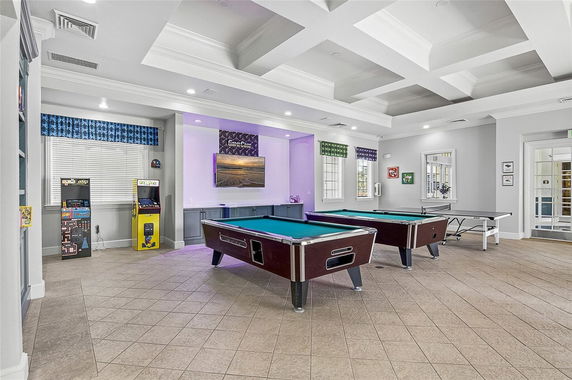 Indoor recreation area with pool tables and arcade machines.
