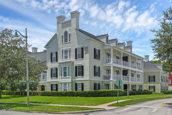 Front view of a multi-story building with balconies and dark shutters.