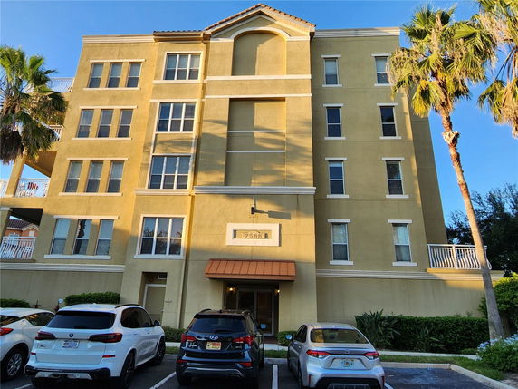 Front view of a multi-story building with parked cars in front.