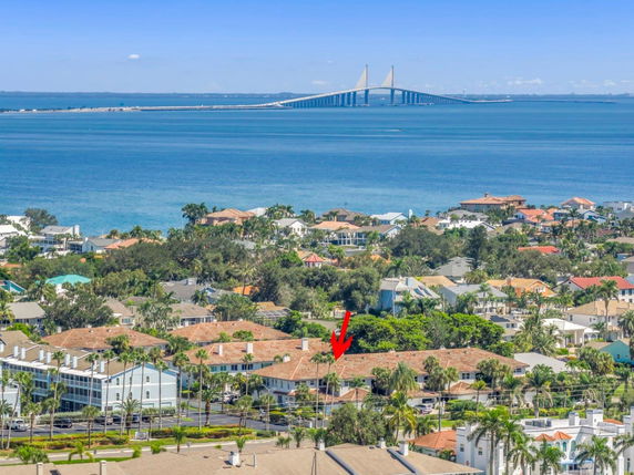 Panoramic view of a coastal residential area with a bridge over the water in the background.