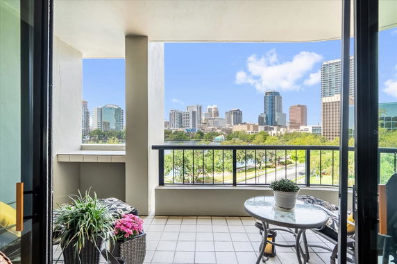 Balcony view overlooking a city skyline with several modern buildings.