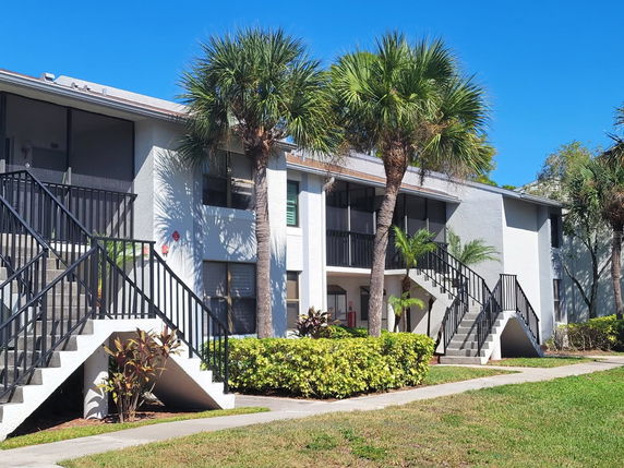 Front view of a two-story apartment building with external staircases.
