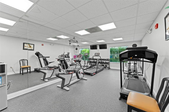 Interior view of a gym with treadmills, exercise bikes, and weights.
