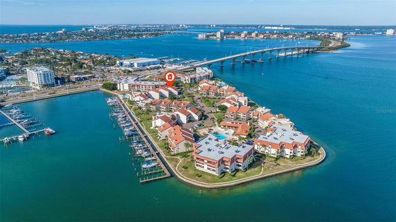 Aerial view of a waterside residential community with multiple buildings and a marina.