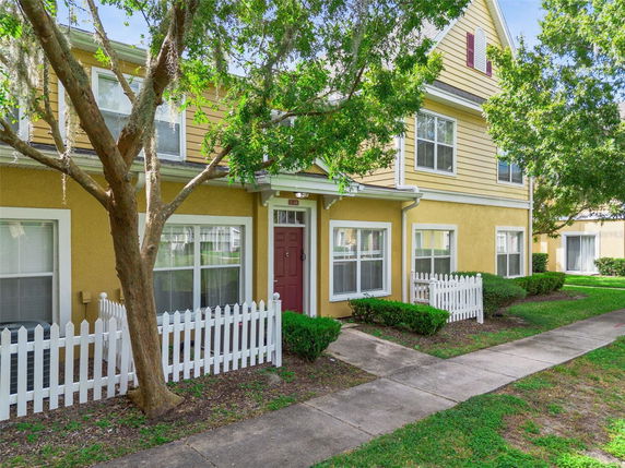 Front view of a two-story house with a small fenced yard and pathway.