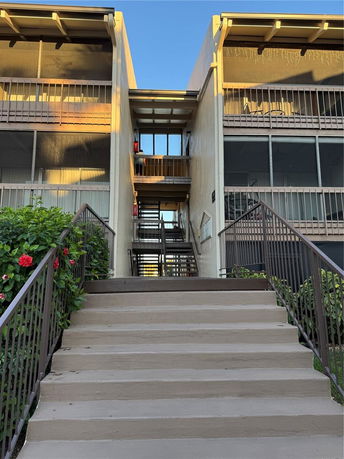 Front view of a multi-story building with exterior staircases and balconies.