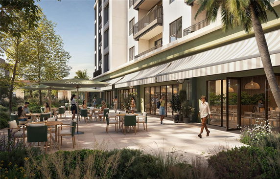 Street-level view of a modern multi-story building with outdoor seating area.