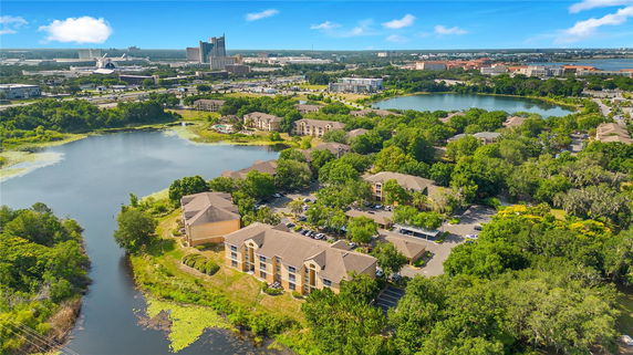 Wide angle view of a housing complex with surrounding greenery and lakes.