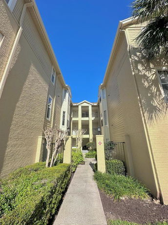 Exterior walkway view leading to a multi-story building entrance.