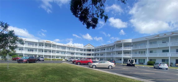 Front view of a three-story apartment building with a decorative facade and balconies.