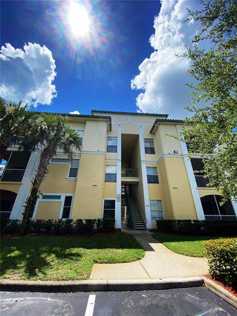 Front view of a multi-story apartment building with an exterior staircase.