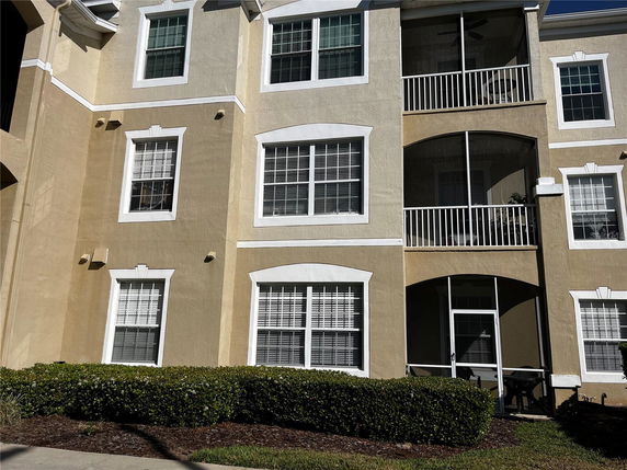 Front view of a multi-story residential building with multiple windows and balconies.