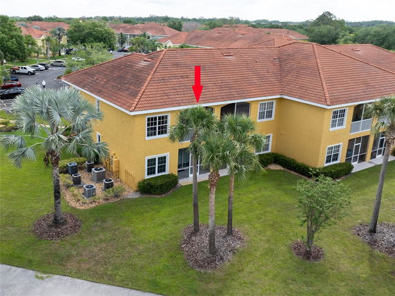 Front view of a two-story building with yellow exterior and red-tiled roof.