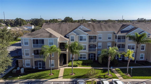 Front view of a multi-story apartment building with balconies and a central entrance.