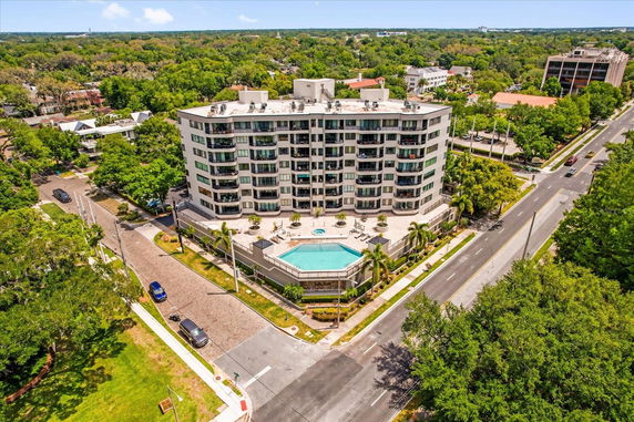 Front view of a six-story apartment building with a swimming pool.