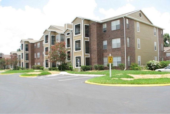 Front view of a multi-story apartment building with brick and siding exterior.