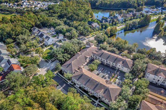 Aerial view of buildings and surrounding areas including a lake.