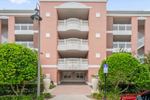 Front view of a multi-story building with balconies and a pink facade.