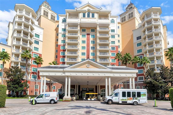 Front view of a multi-story building with balconies and an entrance canopy.