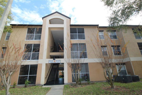 Front view of a multi-story residential building with balconies and a central entrance.