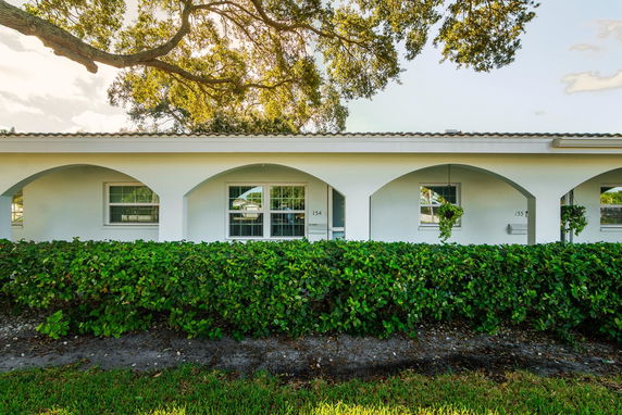 Front view of a building with white arches and windows.