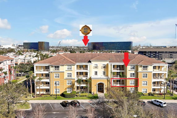 Front view of a multi-story residential building with parking area in front.