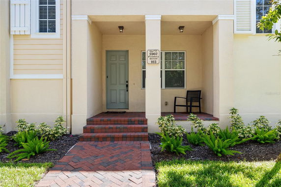 Front view of a house entrance with a small porch and light green door.