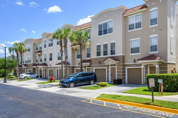 Front view of a multi-story building with garages and balconies.