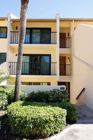 Front view of a multi-story building with balconies and external staircase.