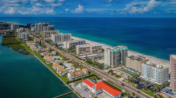 Aerial view of a coastal cityscape with high-rise buildings along the beach and adjacent roadways.