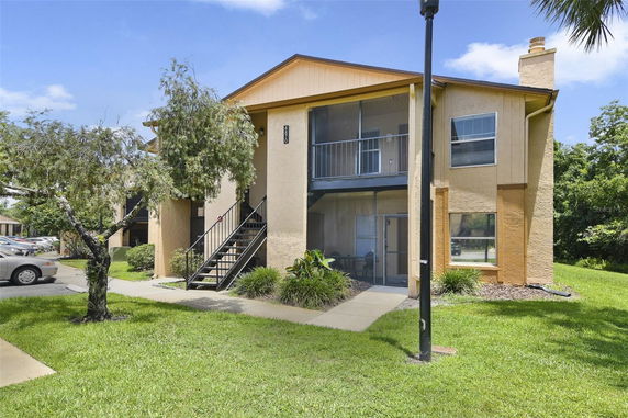 Front view of a two-story apartment building with stairs leading to the upper level.