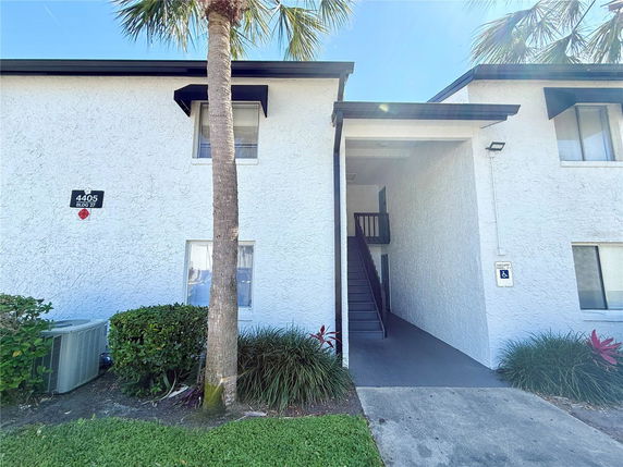 Front view of a two-story building with an entrance and exterior staircase.