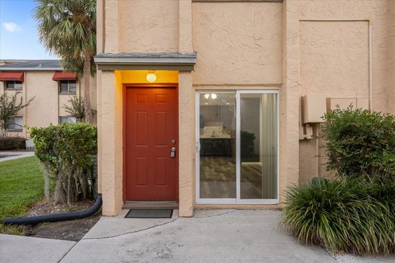 Front view of a building with a red door and sliding glass window