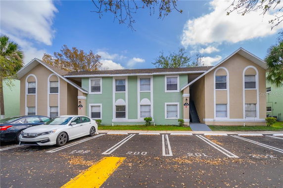 Front view of a two-story apartment building with a parking area.